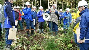 コンテナ苗試験地で森林技術専門官からのコンテナ苗試験地の説明を受ける参加者のみなさん