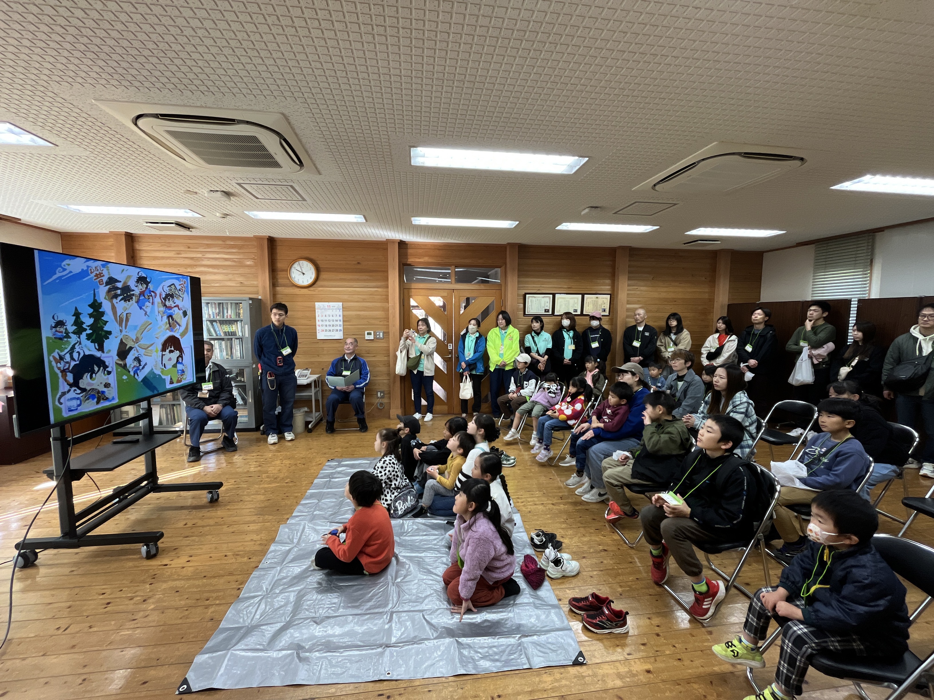 事務所会議室で紙芝居を見る参加者の様子