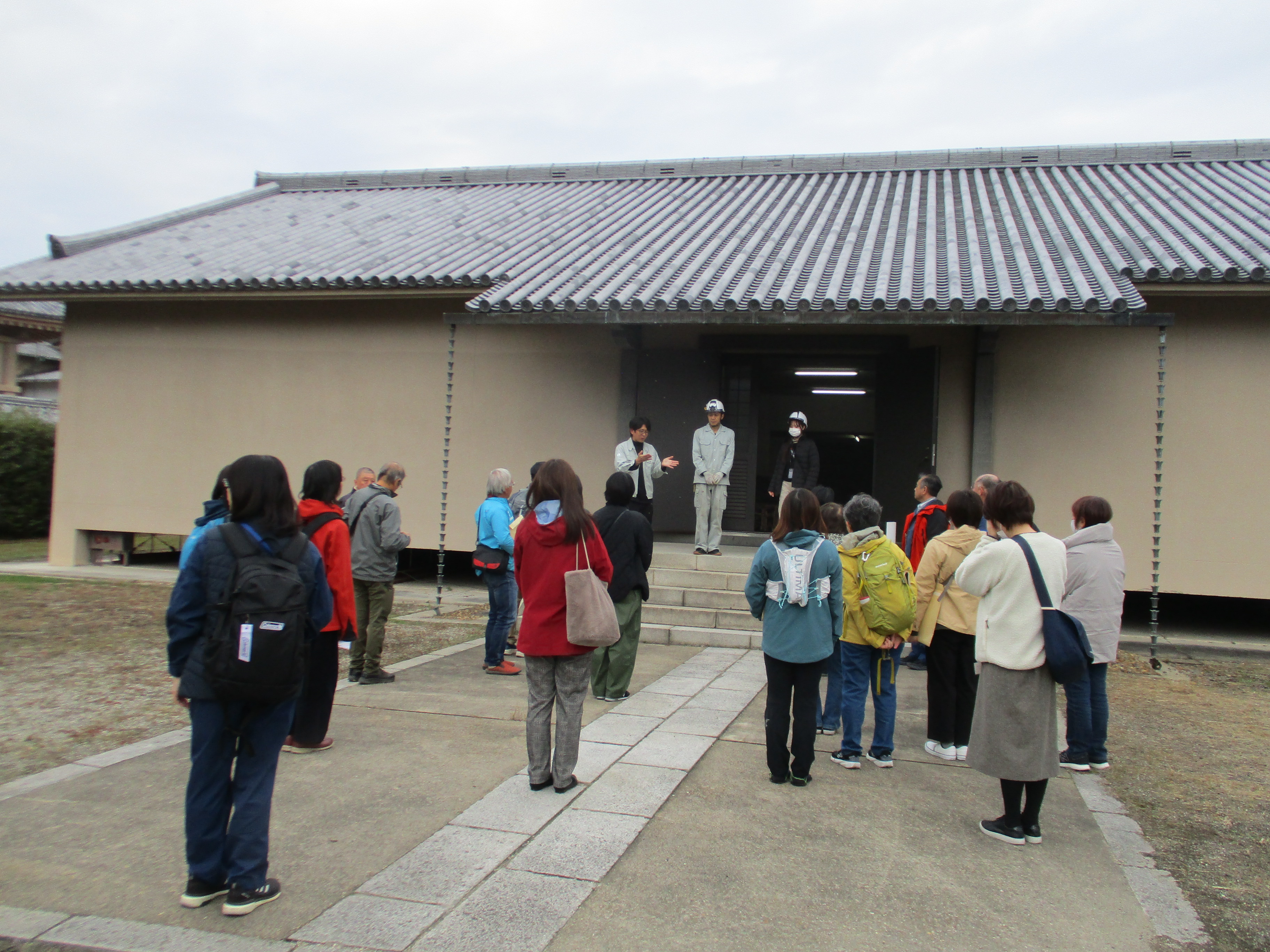 古材保存庫前で説明を聞く参加者の様子